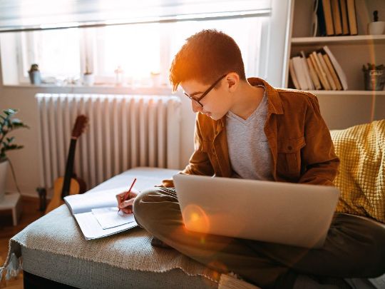 парень делает уроки при свете